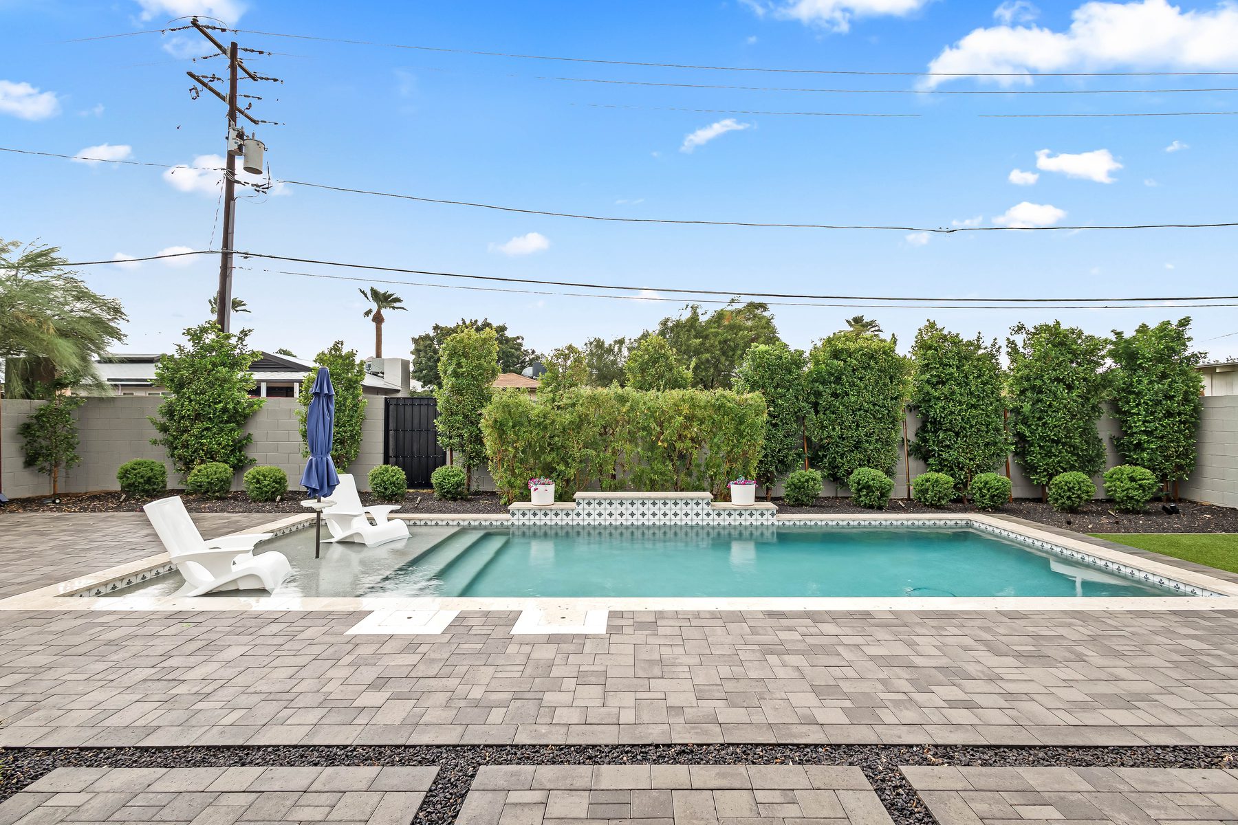 Private play pool with paver patio and hedge screening in the backyard of 5513 E Verde Lane