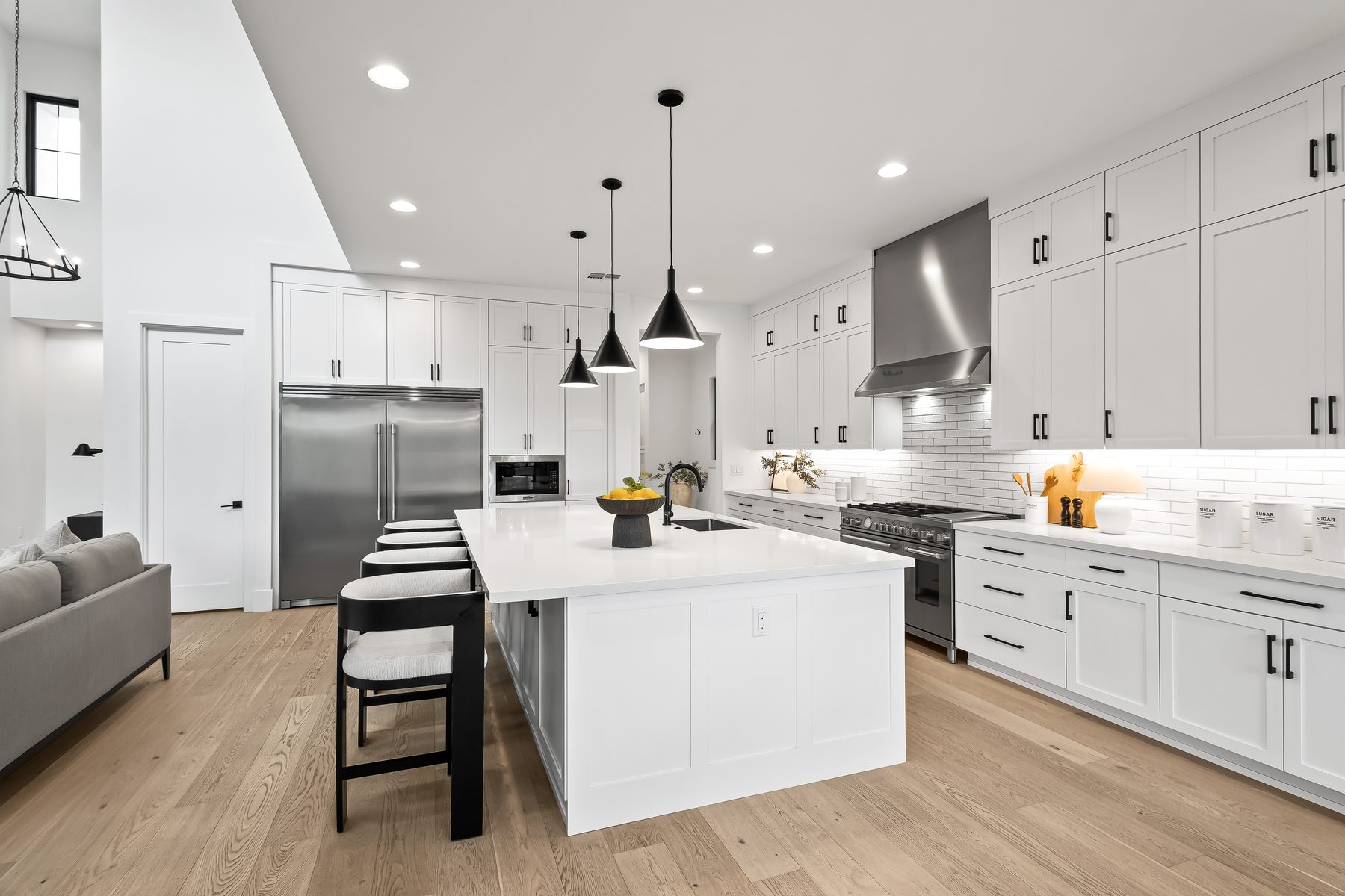 Kitchen with professional gas range, hood, white cabinetry, and oversized island at 5513 E Verde Lane