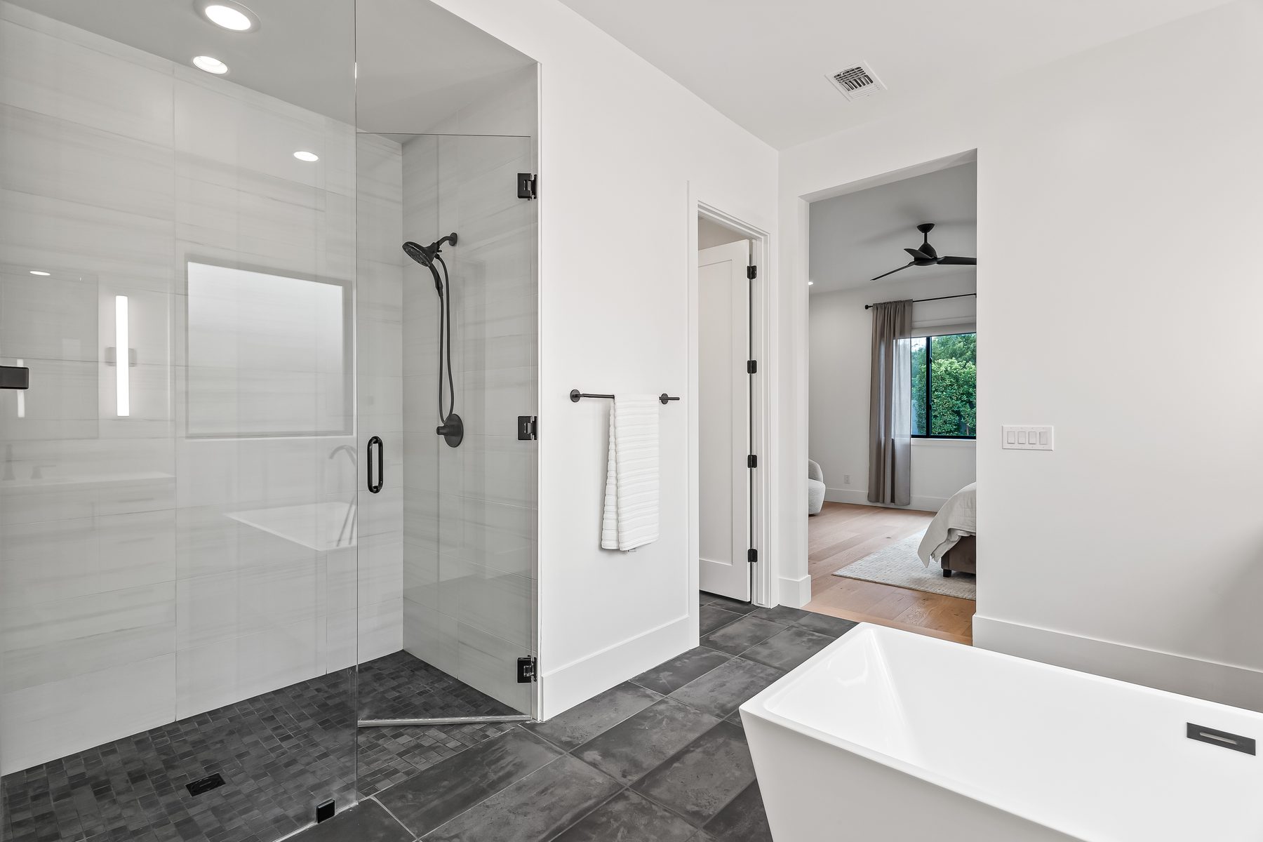 Primary bathroom walk-in glass shower with freestanding tub at 5513 E Verde Lane