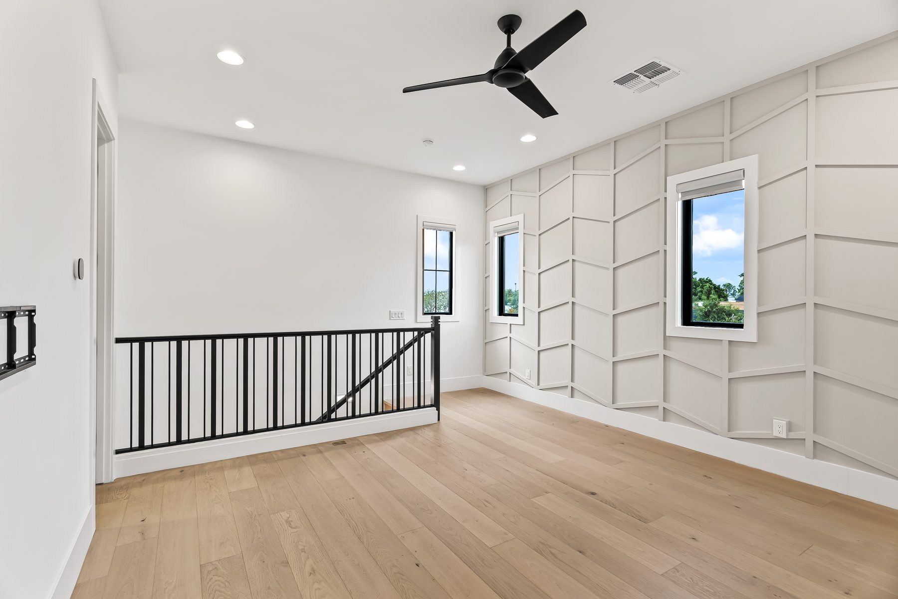 Second-level loft with paneled accent wall and ceiling fan at 5513 E Verde Lane