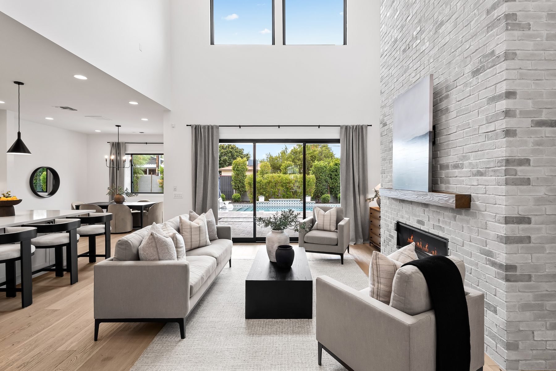 Great room with vaulted ceiling, fireplace, and sliding glass doors facing the pool in Lower Arcadia, Phoenix