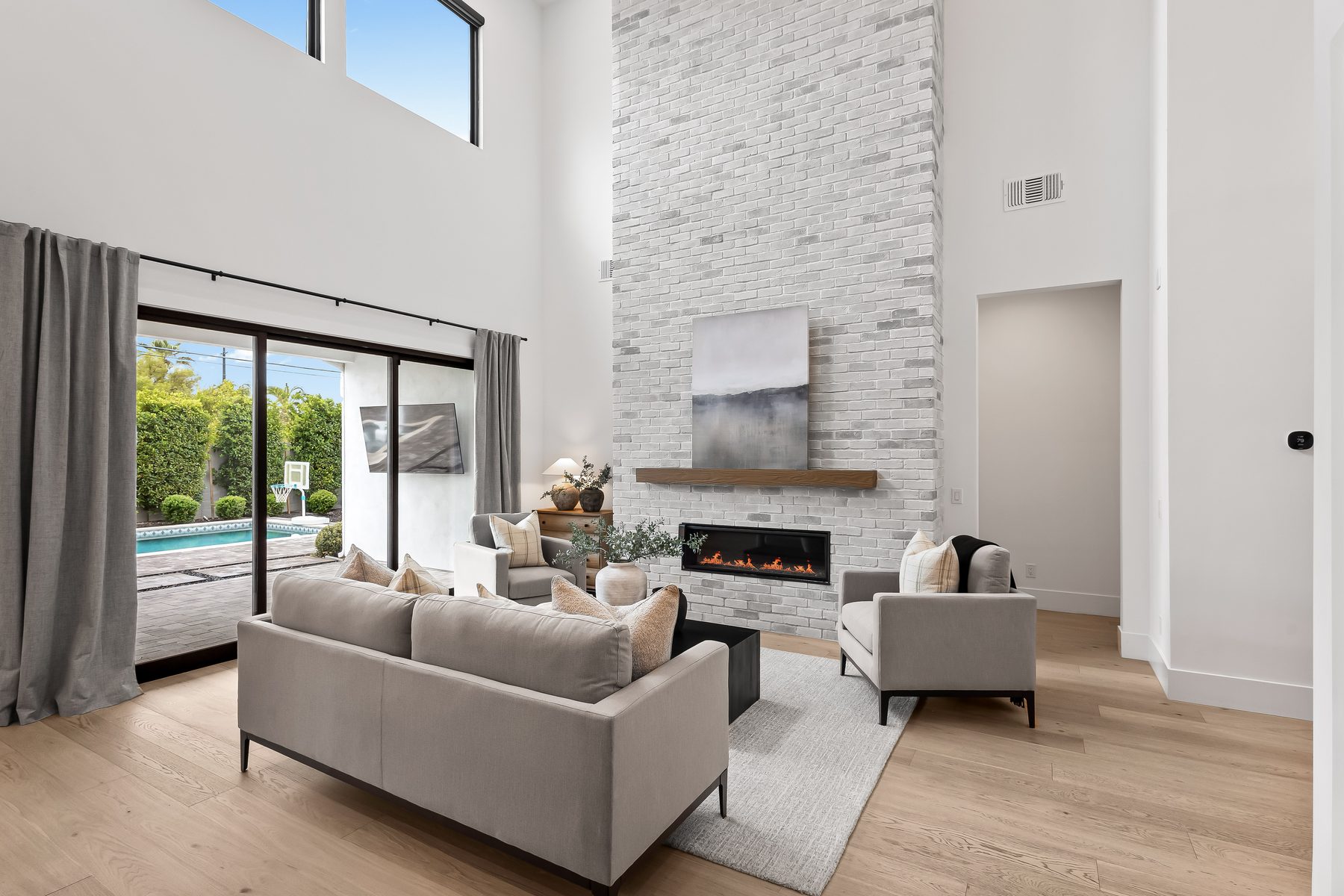 Multi-slide glass doors open from the great room to the covered patio and pool at 5513 E Verde Lane